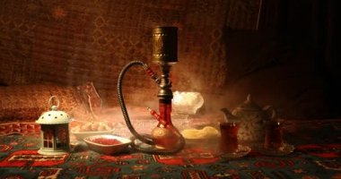 Nargile kömürü nargile kupa Arap iç de buhar bulutları yapma. Şark süsleme halı Doğu çay töreni üzerinde. Şık oryantal shisha içinde karanlık arka ışık ile. Kaymak vurdu