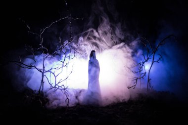 Yalnız kız gece orman veya mavi tonda gece orman sis anda ışıkla. Seçici odak