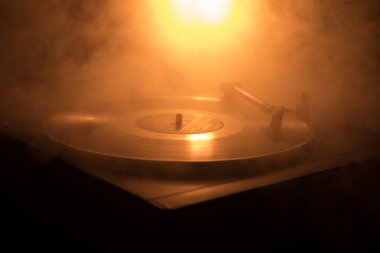 Pikap vinil plak çalar. Retro ses ekipmanları için disk jokey. Dj mix ve müzik çalmak için ses teknolojisi. Yangın arka plan yanan karşı oynanan vinil kaydı