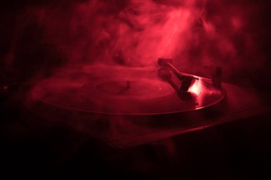 Pikap vinil plak çalar. Retro ses ekipmanları için disk jokey. Dj mix ve müzik çalmak için ses teknolojisi. Yangın arka plan yanan karşı oynanan vinil kaydı