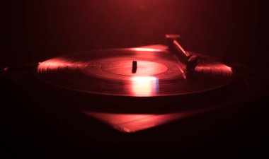 Pikap vinil plak çalar. Retro ses ekipmanları için disk jokey. Dj mix ve müzik çalmak için ses teknolojisi. Yangın arka plan yanan karşı oynanan vinil kaydı