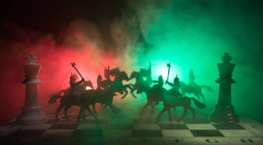 Süvari ve satranç tahtası üzerinde piyade ile ortaçağ savaş sahnesi. Satranç oyununu kavramı iş fikirleri ve rekabet ve strateji fikirler satranç karanlık bir arka plan üzerinde rakamlar. Seçici odak