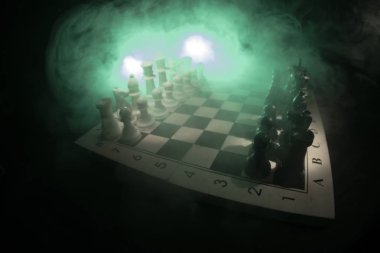 Satranç oyununu kavramı iş fikirleri ve rekabet ve strateji fikirler concep. Satranç figürleri duman ve sis karanlık bir arka plan üzerinde. İş liderlik ve güven kavramı.