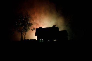 Eski ev gece ormanda bir hayalet veya siste perili korku evi terk etti. Ölü ağaç orman eski mistik binada. Ağaçlar moon ile gece. Gerçeküstü ışıklar