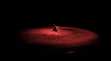 Totem iplik üst iplik, wobbling ve durdurma. Üst tonda duman arka ışıklı ayna yüzeyinde iplik. Eğlenceyi eylem masada karanlık odada.