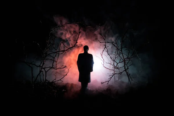 Dziwny sylwetka w ciemnym lesie spooky światłach surrealistyczne nocy, mistyczny krajobraz z creepy człowieka. Stonowanych — Zdjęcie stockowe
