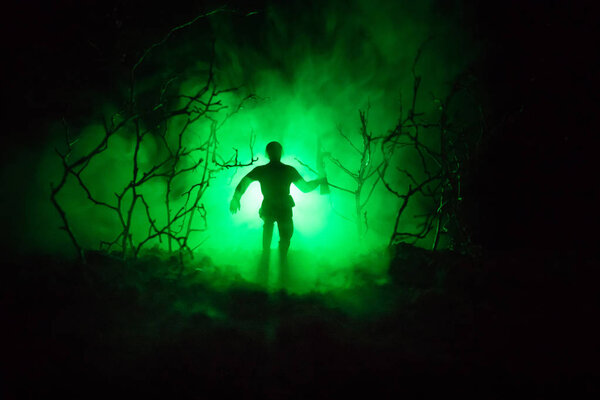 Black silhouettes of soldier in the smoke fire burning moving in battle operation. Back light. Toned