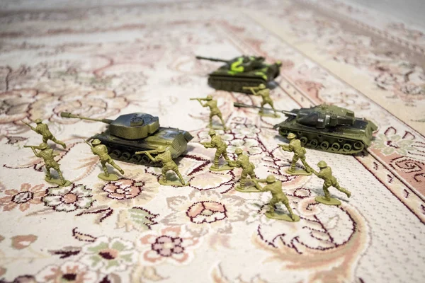 miniature toy soldiers and tank on board. Close up image of toy military at war.