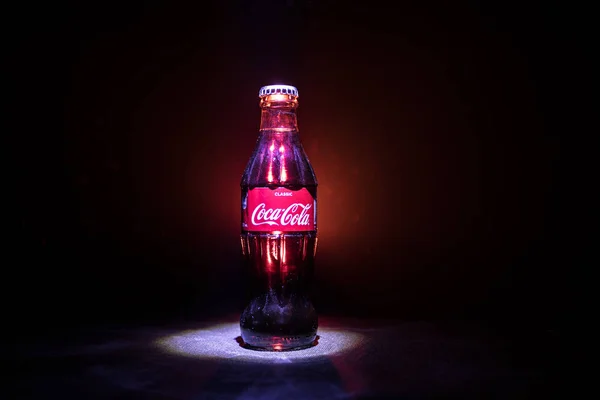 Baku, Azerbeidzjan 13e januari 2018, Coca-Cola Classic in een glazen fles op donker getinte mistige achtergrond. Coca Cola is de meest populaire dranken van koolzuurhoudende frisdrank verkocht over de hele wereld — Stockfoto