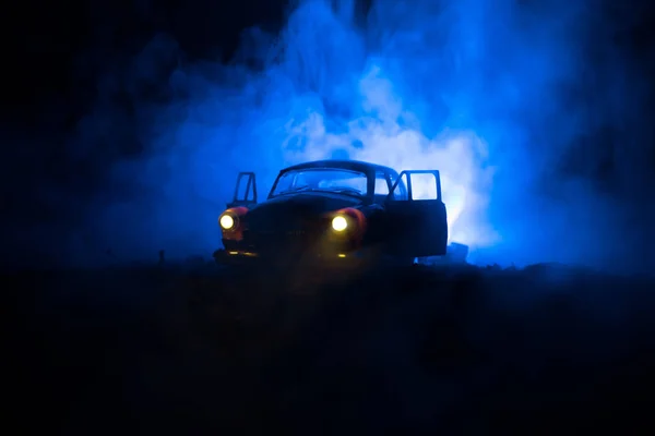 Silhouette des alten Oldtimers in dunkel neblig getönten Hintergrund mit leuchtenden Lichtern bei wenig Licht, oder Silhouette des alten Verbrechens Auto dunklen Hintergrund. — Stockfoto