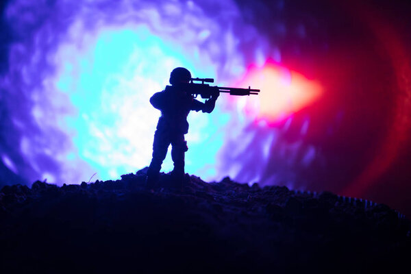 Армейский снайпер с крупнокалиберной снайперской винтовкой ищет убийцу врага. Силуэт на фоне неба. Национальная безопасность обеспечена, военнослужащие на страже
