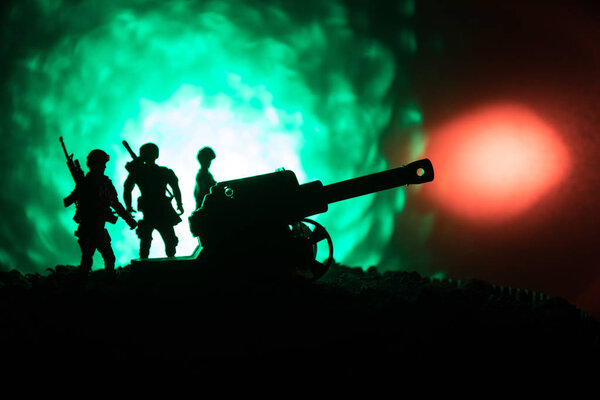 Сцена сражения с артиллерией и стоячими солдатами. Силуэт старого полевого орудия, стоящего на поле, готового стрелять. С ярким темным туманным фоном
.