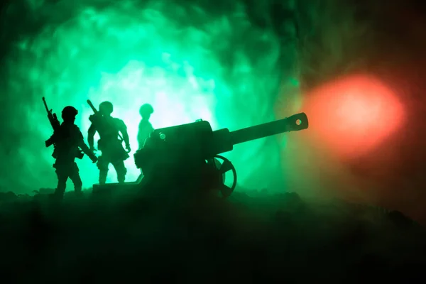 Σκηνή μάχης με arillery και στέκεται στρατιώτες. Σιλουέτα της παλιάς όπλο πεδίο στέκεται στο πεδίο έτοιμο για την πυρκαγιά. Με πολύχρωμα σκούρα ομιχλώδες φόντο. — Φωτογραφία Αρχείου
