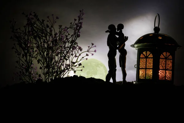 Silhouet van het paar zoenen onder de volle maan. Kerel kus meisje hand op volle maan silhouet achtergrond. Aftelkalender voor Valentijnsdag decor concept — Stockfoto