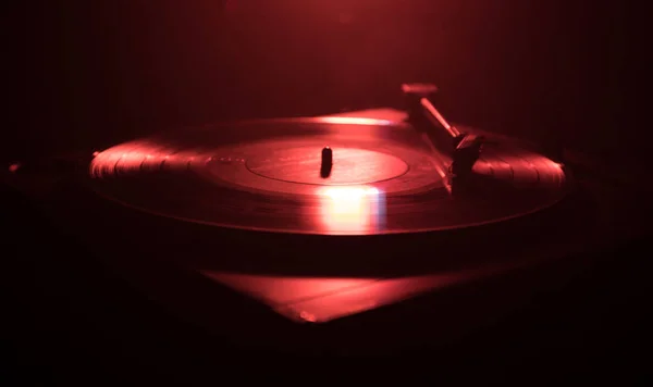 Turntable vinyl record player. Retro audio equipment for disc jockey. Sound technology for DJ to mix & play music. Vinyl record being played against burning fire background — Stock Photo, Image