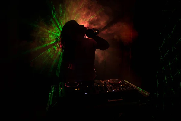 DJ Spinning, Mixing, and Scratching in a Night Club, Hands of dj tweak vari controlli delle tracce sul ponte del DJ, luci stroboscopiche e nebbia, o Dj mixa la traccia nel nightclub alla festa — Foto Stock
