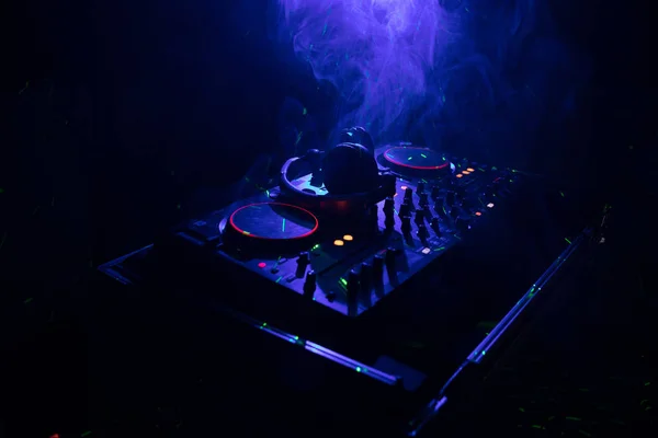 DJ Spinning, Mixing, e Scratching in a Night Club, Mãos de dj ajustam vários controles de pista no deck do dj, luzes estroboscópicas e nevoeiro, ou Dj mistura a faixa na boate na festa — Fotografia de Stock