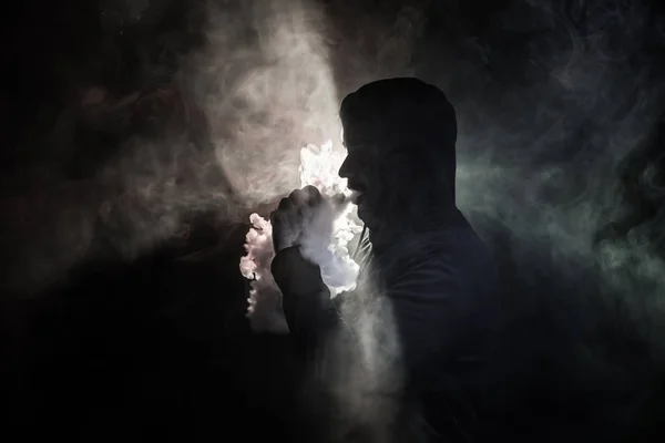 Vaping pria memegang mod. Awan Uap. Latar belakang hitam Menguap rokok elektronik dengan banyak asap. Konsep Vape — Stok Foto