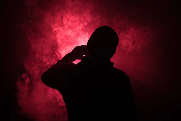 Hombre aspirante sosteniendo un mod. Una nube de vapor. Fondo negro. Vapeando un cigarrillo electrónico con mucho humo. Concepto de Vape — Foto de Stock