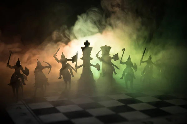 中世纪战斗场面与骑兵和步兵在棋盘上。棋盘游戏概念的商业理念和竞争策略想法在黑暗背景下国际象棋人物。选择性聚焦 — 图库照片
