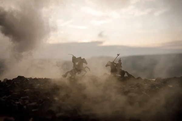 Utkat se mezi dvěma rytíři na koních. Západ slunce na pozadí. Selektivní fokus — Stock fotografie