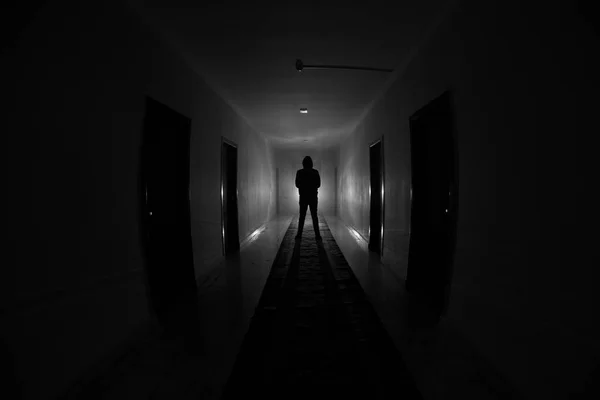 Siluetă înfiorătoare în clădirea întunecată abandonată. Coridor întunecat cu uși de dulap și lumini cu siluetă de persoană înfricoșătoare de groază în picioare cu diferite poziții . — Fotografie, imagine de stoc