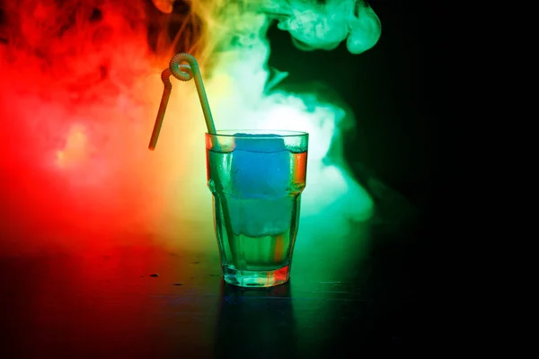 Алкогольний коктейль у склянці з льодом у диму на темному фоні. Клуб п'є концепцію. Одна склянка коктейлю. Вибірковий фокус — стокове фото