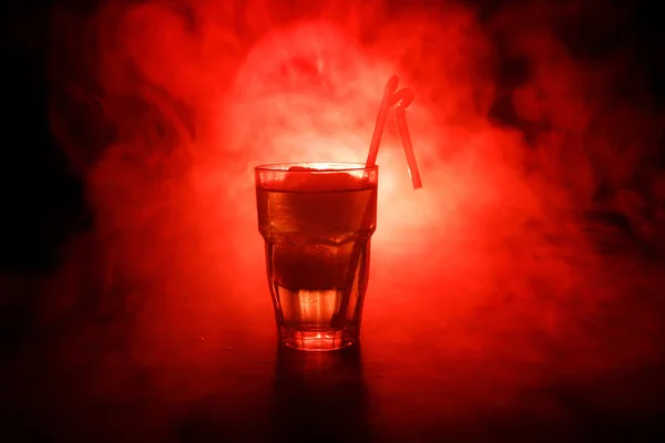 Cóctel de alcohol en vaso con hielo en humo sobre fondo oscuro. Concepto de bebidas club. Una copa de cóctel. Enfoque selectivo — Foto de Stock