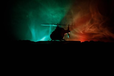 Askeri helikopter çatışma bölgesinden uçmaya hazır silüeti. Gece görüntüleri çöl sisli tonda sırt ile başlayarak helikopter ile dekore edilmiştir. Seçici odak.