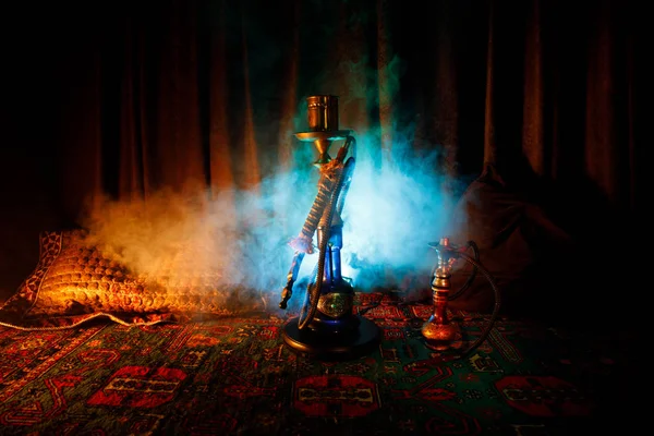 水烟碗上的水烟热煤制作阿拉伯内部的蒸汽云。地毯上的东方装饰品。时尚的东方水烟在黑暗中与背光。水烟广告 — 图库照片