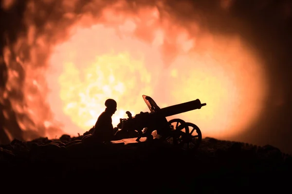 Hombre con ametralladora por la noche, fondo de explosión de fuego o siluetas militares escena de lucha en el fondo del cielo niebla de guerra, Soldados de la Guerra Mundial siluetas debajo del horizonte nublado Por la noche . —  Fotos de Stock