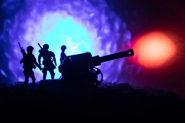 Battle scène met arillery en staande soldaten. Silhouet van oude veld pistool staan op het veld klaar om te vuren. Met kleurrijke donkere mistige achtergrond. — Stockfoto