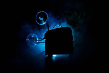 Eski stil film projektör, yakın çekim. Film projektör dramatik aydınlatma ve seçici odak ahşap bir zemin üzerine. Film ve eğlence kavramının