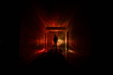 Ürpertici siluet koyu terk edilmiş binada. Kabine kapılar ve ışıkları ile farklı pozlar duran korkunç korku kişi silueti ile karanlık koridor.