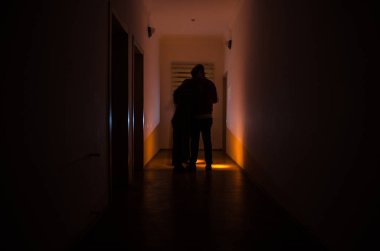 Kabine kapılar ve korkunç korku adam ile farklı pozlar ayakta silüeti ışıklarla karanlık koridor.