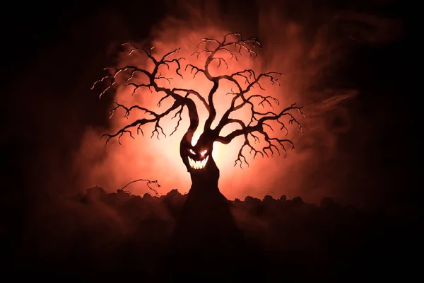 Silhueta de árvore de Halloween assustador com rosto de horror no fundo escuro enevoado tonificado com a lua no lado de trás. Árvore de horror assustador com rostos de zumbis e demônios . — Fotografia de Stock