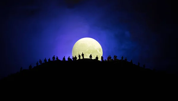 Vue effrayante foule de zombies sur la colline avec ciel nuageux effrayant avec brouillard et pleine lune montante. Groupe de silhouette de zombie marchant sous la pleine lune . — Photo