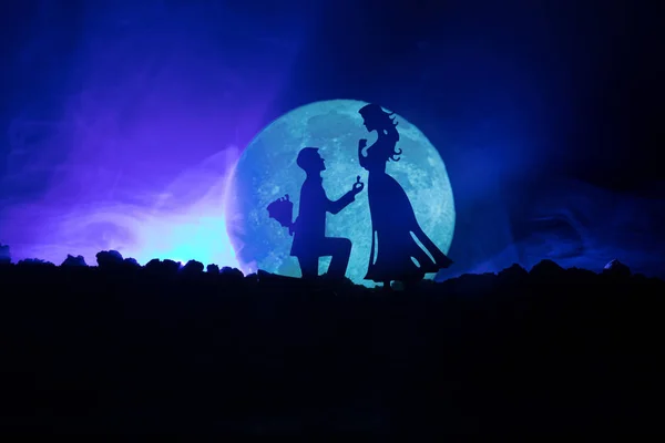 Niesamowita scena miłosna. Sylwetki człowieka Dokonywanie wniosku kobieta lub sylwetki para przeciwko duży Księżyc w tle — Zdjęcie stockowe