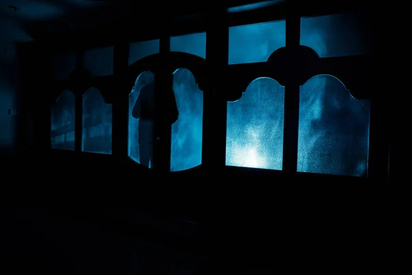 Silueta neznámý stín postavy na dveře zavřené dveře. Silueta člověka před oknem v noci. Strašidelné scény halloween pojmu rozmazané siluety — Stock fotografie