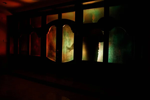 Sylwetka figura nieznany cień na drzwi, przez zamknięte drzwi. Sylwetka człowieka przed oknem w nocy. Koncepcja halloween przerażające sceny nieostre sylwetki — Zdjęcie stockowe