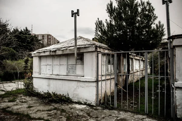 Edifício abandonado da casa da aldeia no jardim botânico de Baku. Ninguém no parque com árvores. Primavera. — Fotografia de Stock