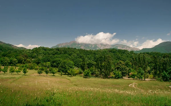 Paesaggio maestoso di montagne e prato. Strada di montagna in bicicletta. Strada di montagna nebbiosa in alta montagna.. Cielo nuvoloso con strada di montagna . — Foto Stock