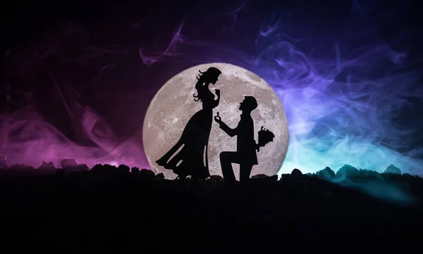 Incredibile scena d'amore. Silhouette di uomo che fa proposta alla donna o Silhouette di coppia contro la luna grande sullo sfondo — Foto Stock