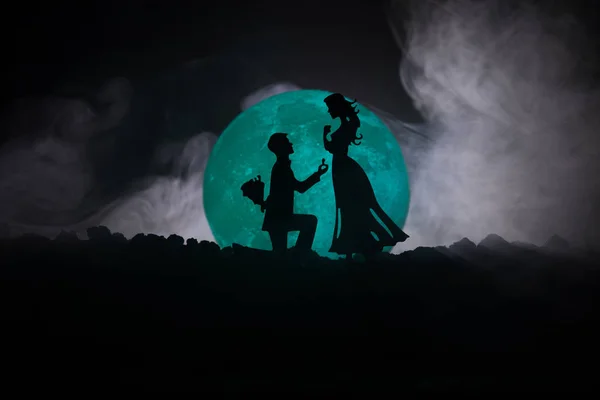 Superbe scène d'amour. Silhouettes de l'homme faisant la proposition à la femme ou Silhouettes de couple contre la grande lune en arrière-plan — Photo