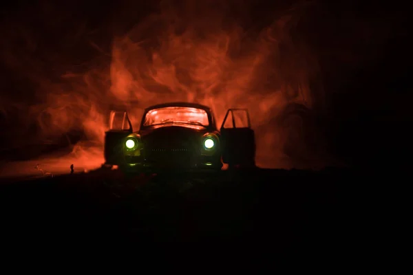 Silueta starých veteránů v mlhavé tmě laděných pozadí s zářící světla v slabém osvětlení nebo silueta starých zločin auto tmavé pozadí. — Stock fotografie