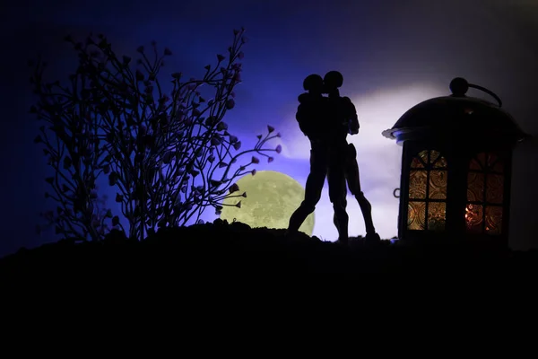 Silhouette di coppia che si bacia sotto la luna piena. Guy bacio ragazza mano su sfondo silhouette luna piena. Giorno di San Valentino concetto di arredamento — Foto Stock