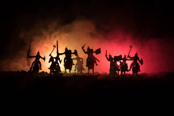 Medieval battle scene with cavalry and infantry. Silhouettes of figures as separate objects, fight between warriors on dark toned foggy background. Night scene. — Stock Photo, Image