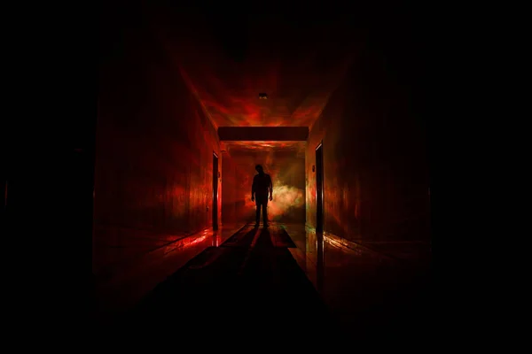 Silhouette effrayante dans le bâtiment sombre abandonné. Couloir sombre avec portes d'armoire et lumières avec silhouette d'horreur effrayant personne debout avec différentes poses . — Photo