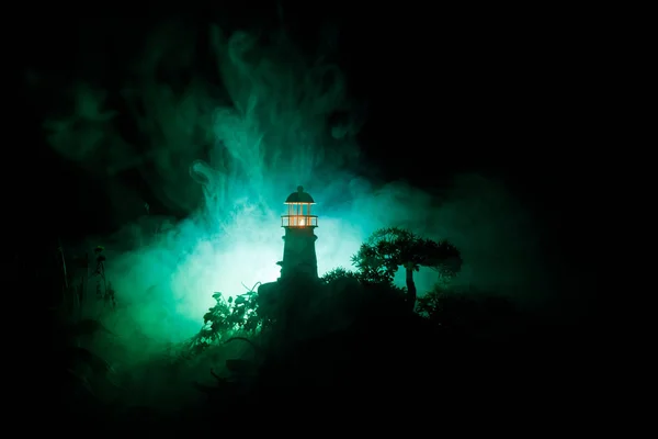 Latarnia morska z wiązki światła w nocy z mgły. Stara latarnia morska stojąc na góry. Dekoracja stołu. Selektywny fokus — Zdjęcie stockowe