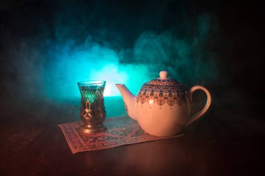 Geleneksel glasse ve ışıklar ve duman siyah zemin üzerine pot Doğu tea. Doğu çay kavramı. Armudu geleneksel Azerbaycan/Türkiye Kupası